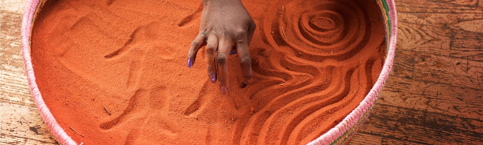 Drawing symbols in the sand with fingers