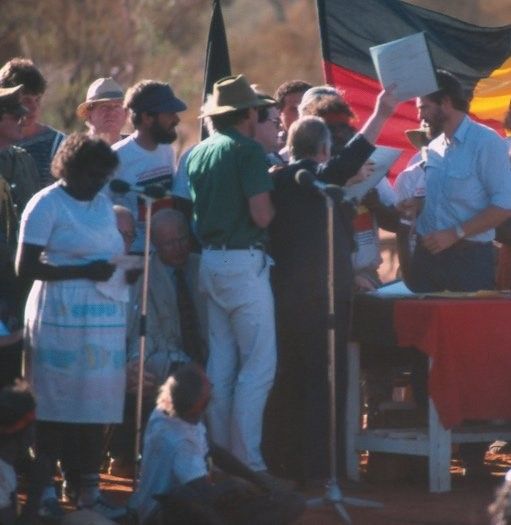 Governor-General Sir Ninian Stephen holds document aloft at handback ceremony.