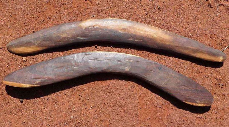 Two boomerangs resting on the ground.